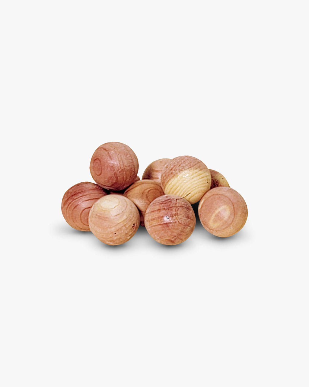 A small pile of round wooden cedar moth balls in natural light brown and tan wood tones, photographed on a clean white background.